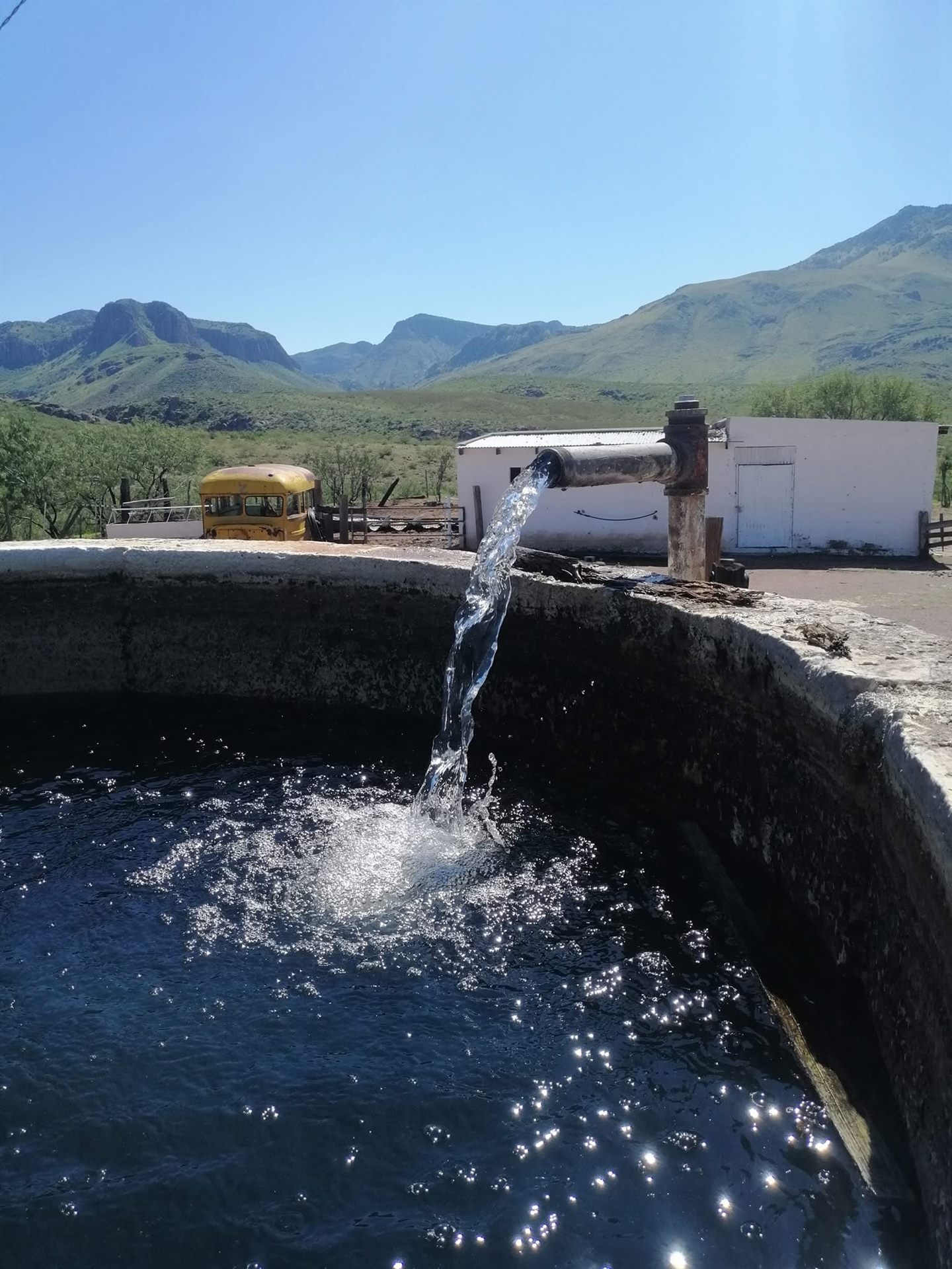 Agua de pozo solar llenando tanque en la sierra